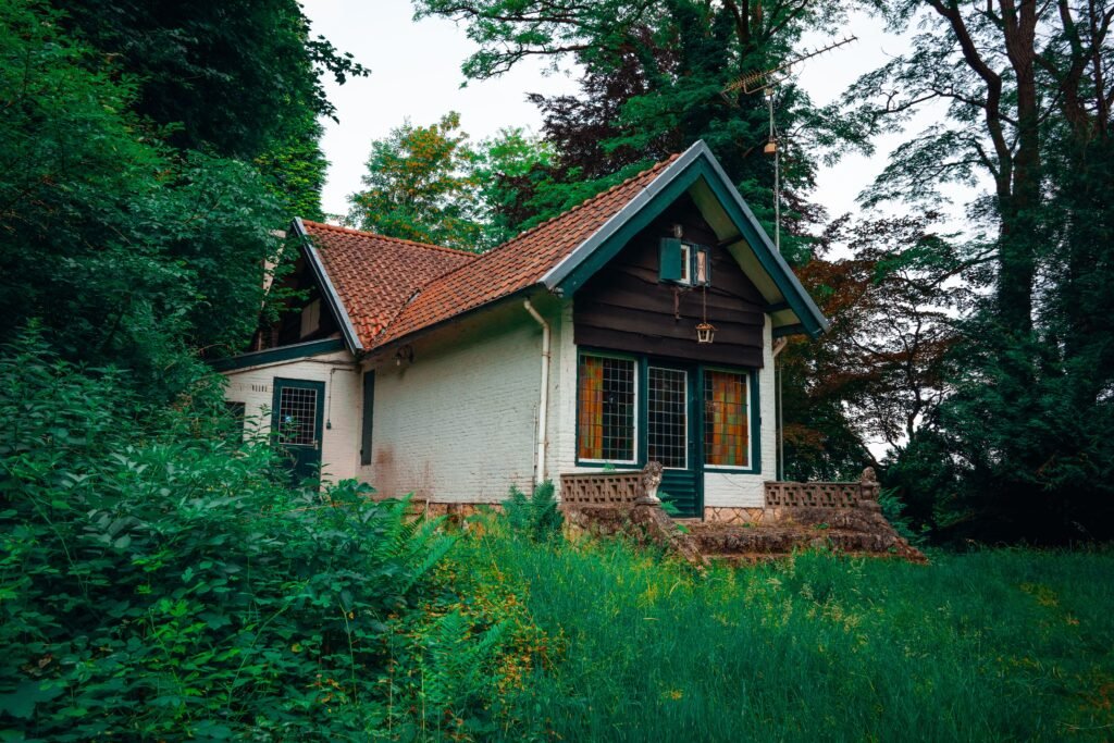 A quaint cottage surrounded by lush greenery in a serene forest setting, ideal for retreat seekers.